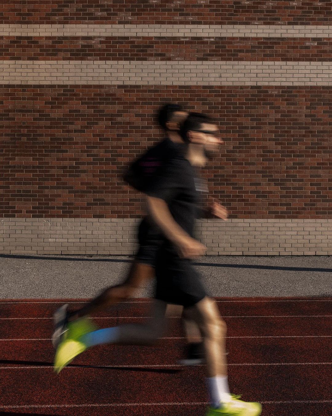 Two men are blurred out as they are pictured running on a track.