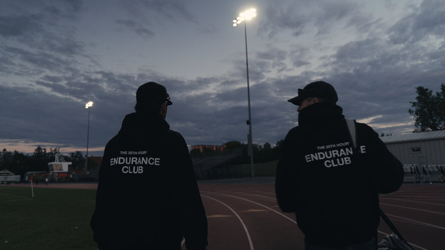 Two runners in Endurance Club hoodies at the track